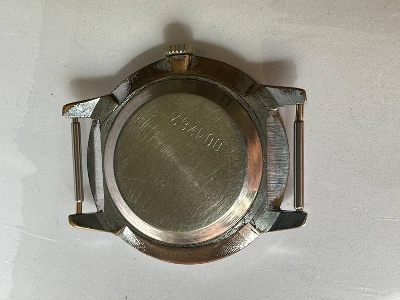 May include: The back of a silver wristwatch with a round case and a metal band. The watch face has a number "607425" printed on it.