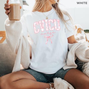 May include: White t-shirt with a pink floral design that says "CVICU nurse" with a pink ribbon underneath.