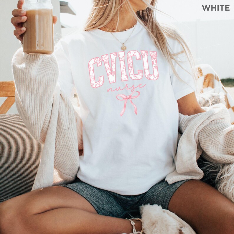 May include: White t-shirt with a pink floral design that says "CVICU nurse" with a pink ribbon underneath.