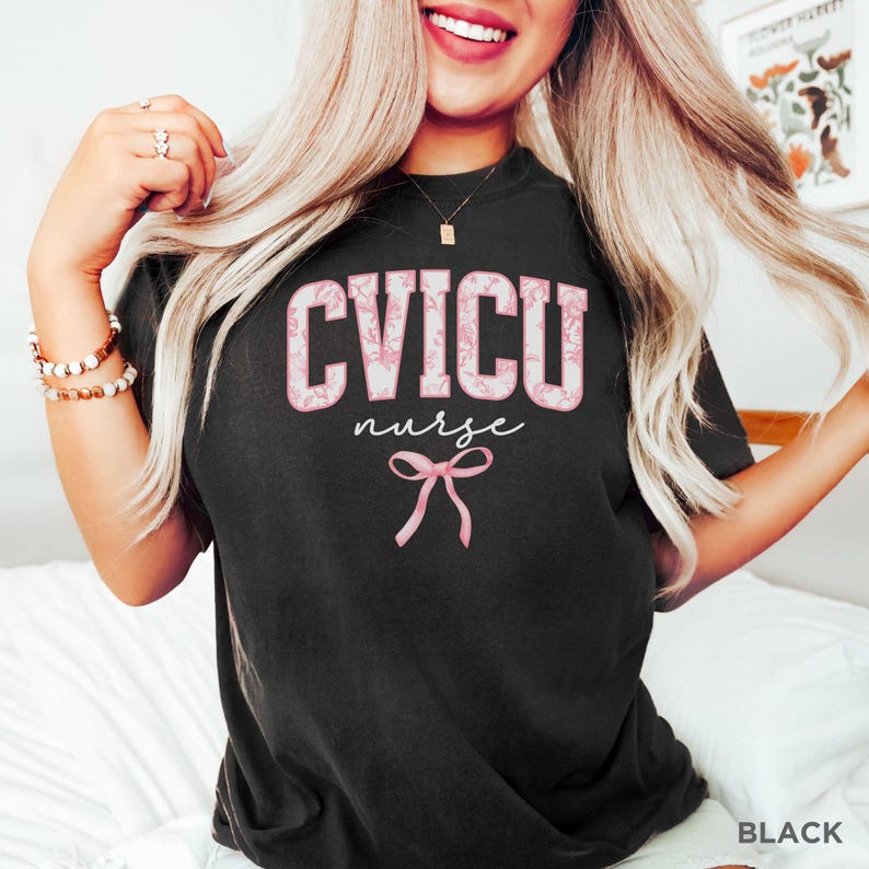 May include: Black t-shirt with a pink floral design that says "CVICU nurse" with a pink bow underneath.