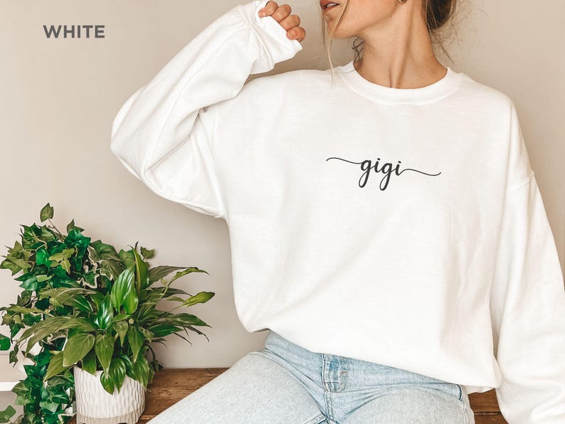 May include: White sweatshirt with the word "gigi" written in cursive on the front.
