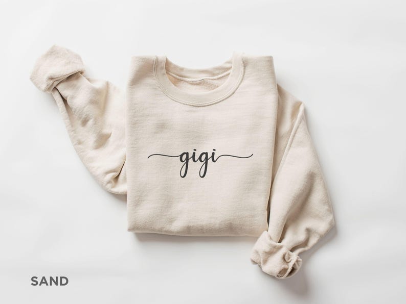 May include: A sand-colored sweatshirt with the word "gigi" written in cursive on the front.