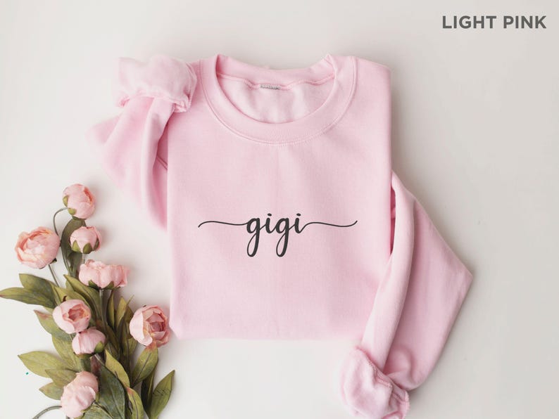 May include: Light pink sweatshirt with the word "gigi" written in black cursive script.