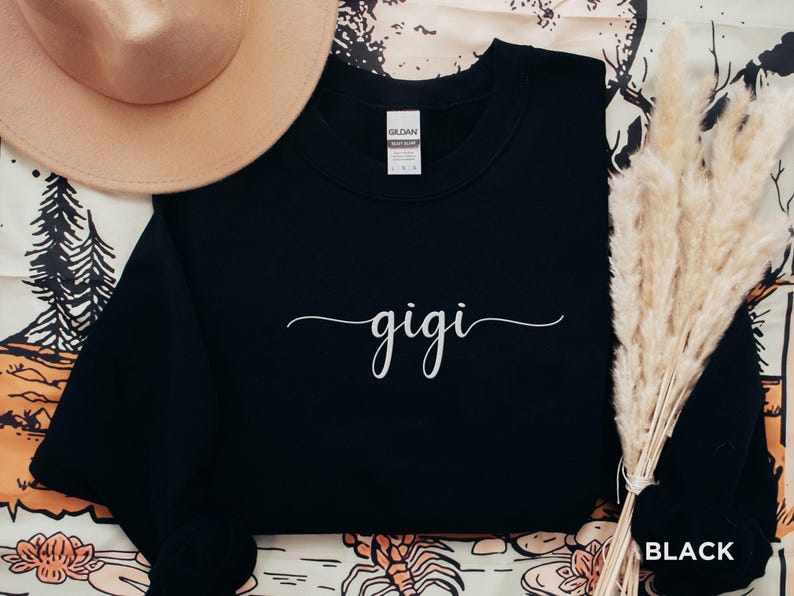 May include: Black sweatshirt with the word "gigi" written in white cursive script.
