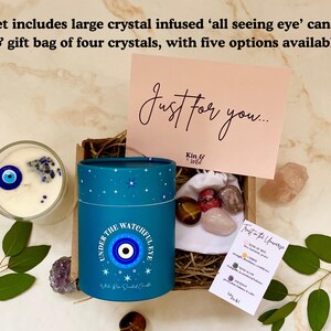 Puede incluir: Un juego de regalo con una vela grande con infusi&oacute;n de cristal con un dise&ntilde;o de "ojo que todo lo ve", una bolsa de regalo de cristales y una tarjeta que dice "Just for you...". La vela est&aacute; en un recipiente de vidrio.