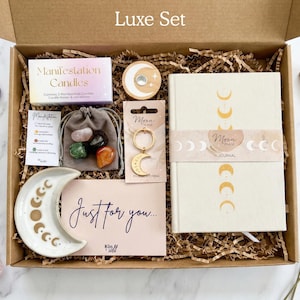 Manifestation gift set in size luxe - a spiritual gift that comes gift wrapped and includes manifestation candles, a set of four healing crystals, spell candle holder, crescent moon keyring and moon phases trinket dish