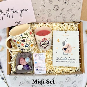 May include: A gift box with a floral mug, a candle with "MUM" in a heart, a facial mask, crystals, and a card that says "Just for you...". The box is labeled "Midi Set".