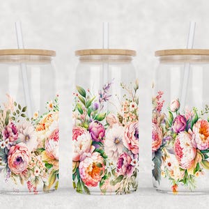 May include: Three clear glass tumblers with wooden lids and white straws. Each tumbler features a floral design with pink, white, and orange flowers.