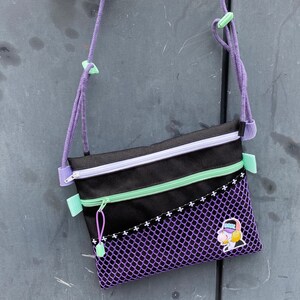 SACOCHE23 - leichte, sportliche Tasche zum Umhängen mit 4 Fächern aus Outdoor Stoff und lila Netz Stoff mit coolem Bubblegum-Girl-Patch