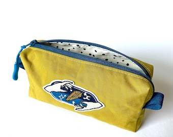 Small cosmetic bag / tobacco bag made of dry oilskin in mustard yellow based on my FEEDBAG pattern with a cool patch