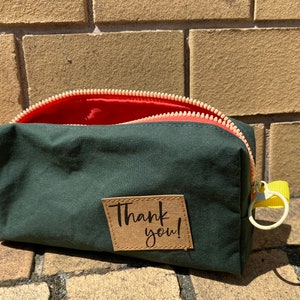 Kleine Kosmetiktasche / Tabaktasche aus Dry Oilskin in dunkelgrün nach meinem Schnittmuster FEEDBAG mit Etikett „Thank you“