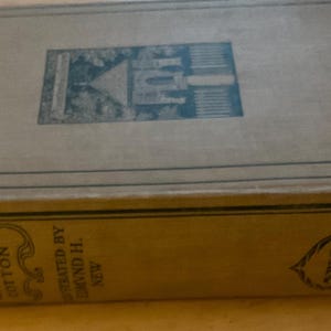 May include: An antique book titled "The Compleat Angler" by Walton & Cotton. The book has a light brown cover with a teal illustration and text. The spine displays the title and author's name. The book is in good condition.