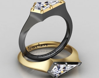 Pode incluir: Dois anéis com um design moderno. Os anéis apresentam uma banda preta com uma moldura dourada que segura uma pedra transparente de corte retangular. O nome da marca "Jewelsy" está gravado no interior da banda do anel.
