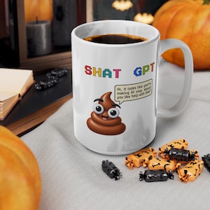 Könnte beinhalten: Ein weißer Keramikbecher mit dem Text SHAT GPT in bunten, verpixelten Buchstaben. Unter dem Text befindet sich ein braunes Cartoon-Kackhaufen-Emoji mit großen Augen und einer Sprechblase mit dem Text, Hi, it looks like you're making AI slop. Would you like help with that?