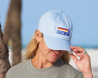May include: A light blue baseball cap with a rainbow stripe and the text "OCEAN DUTY" on the front.