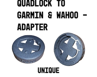 May include: Two black plastic adapters for mounting a Garmin or Wahoo cycling computer to a Quadlock mount. The text "QUADLOCK TO GARMIN & WAHOO - ADAPTER" is above the adapters. The text "UNIQUE" is below the adapters.