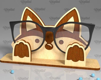 Könnte beinhalten: Ein Brillenhalter aus Holz in Form eines Fuchses, der eine Brille trägt. Der Fuchs ist braun und hat eine weiße Nase und einen weißen Mund. Die Brille ist schwarz mit klaren Gläsern. Der Halter ist 3 mm dick.