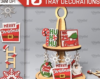 May include: A collection of 10 Christmas-themed tiered tray decorations. The decorations include Santa Claus, snowflakes, candy canes, and signs with text like "Merry Christmas" and "Welcome to the North Pole". The image also includes the text "SVG-DXF PNG-JPG".