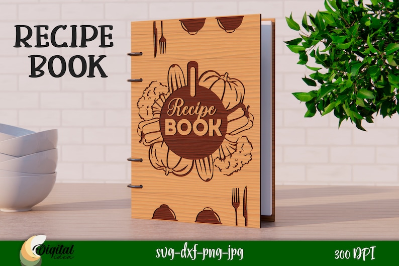 Może przedstawiać: Drewniana okładka książki kucharskiej z brązowym tłem i k&oacute;łkiem z tekstem "Recipe Book" otoczonym warzywami. Okładka ma r&oacute;wnież widelec i n&oacute;ż w prawym dolnym rogu.