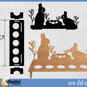May include: Black and brown wooden Easter egg holder with six slots. The holder features a silhouette of two rabbits with a nest of eggs. The holder is 25 cm tall.