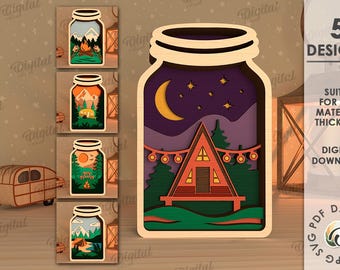 May include: Five digital designs of a mason jar with a layered scene inside. The designs include a campfire, a mountain range, a sunset, a lake, and a cabin with a crescent moon and stars. The designs are suitable for any material thickness.