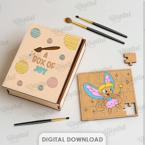 May include: A wooden box with the text "A Box of Joy" and colourful dot designs. A wooden jigsaw puzzle with a fairy illustration is next to the box. Paintbrushes and a paint palette are also visible.
