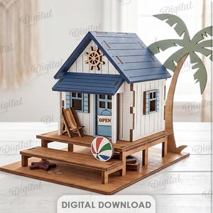 Könnte beinhalten: Ein Strandhausmodell aus Holz mit blauem Dach, weißen Wänden und einer Palme. Die Struktur verfügt über eine Terrasse mit Strandstuhl, einem bunten Strandball und einem Seestern. Ein Schild an der Tür trägt die Aufschrift OPEN. Materialbreite 3 mm.