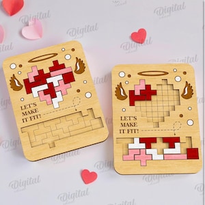 May include: Two wooden heart-shaped puzzles with the text "LET'S MAKE IT FIT!" and a pixelated heart design in red, pink, and white. The puzzles are surrounded by paper hearts.