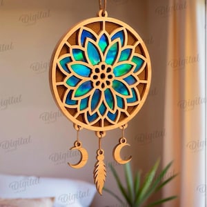 Peut inclure: Un attrape-r&ecirc;ves en bois avec un motif floral et un centre bleu et vert iris&eacute;. L'attrape-r&ecirc;ves comporte trois breloques suspendues : une plume et deux croissants de lune. Convient &agrave; toutes les &eacute;paisseurs de mat&eacute;riau.