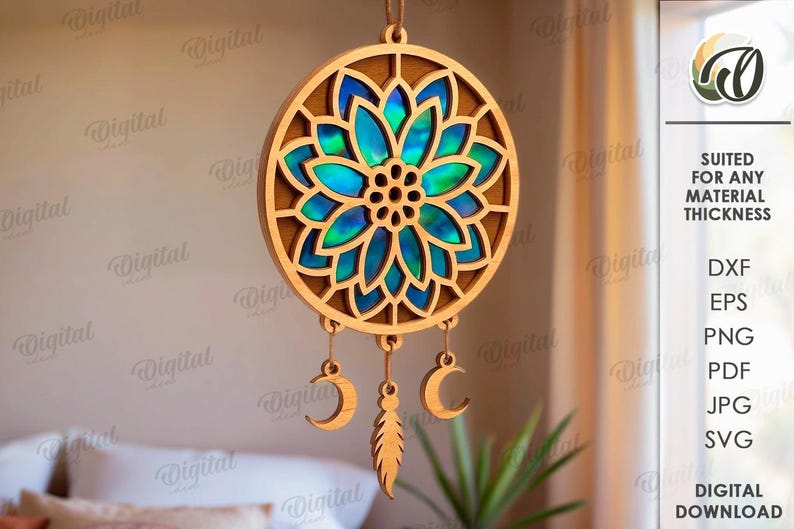 Peut inclure: Un attrape-r&ecirc;ves en bois avec un motif floral et un centre bleu et vert iris&eacute;. L'attrape-r&ecirc;ves comporte trois breloques suspendues : une plume et deux croissants de lune. Convient &agrave; toutes les &eacute;paisseurs de mat&eacute;riau.