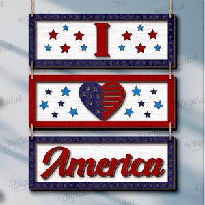 Peut inclure: Trois panneaux rectangulaires en bois sur le th&egrave;me patriotique. Le panneau sup&eacute;rieur indique "I" avec des &eacute;toiles rouges et bleues. Le panneau du milieu pr&eacute;sente un c&oelig;ur avec des &eacute;toiles. Le panneau inf&eacute;rieur dit "America" en script rouge.