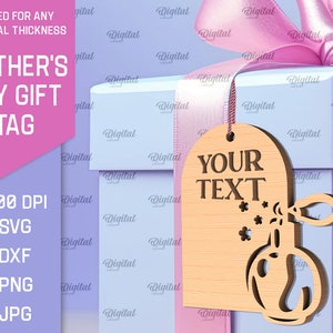 May include: A wooden gift tag with a perfume bottle design and the text "YOUR TEXT". The tag is light brown and has a white background. The tag is tied with a pink ribbon and is sitting on top of a light blue gift box.