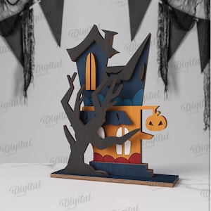 May include: A multi-layered Halloween-themed wooden house decoration. The house features a dark blue roof, orange walls, and a carved tree. A pumpkin with a carved face hangs from the house. The material width is 3 mm.