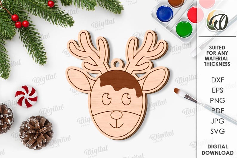 May include: A wooden reindeer head ornament with a light brown face and antlers, and a darker brown section on top. The ornament has a small hole for hanging. The image also includes text that says "SUITED FOR ANY MATERIAL THICKNESS" and "DIGITAL DOWNLOAD".