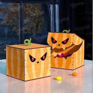 K&ouml;nnte beinhalten: Zwei h&ouml;lzerne Halloween-Boxen mit geschnitzten K&uuml;rbisgesichtern. Die Boxen sind orange und braun mit gr&uuml;nen Stielen. Eine Box ist ge&ouml;ffnet und zeigt bunte S&uuml;&szlig;igkeiten. Die Boxen stehen auf einer wei&szlig;en Oberfl&auml;che.