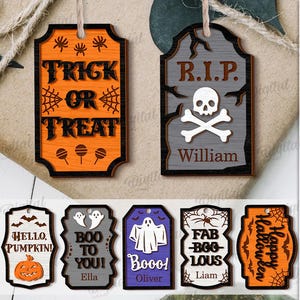 May include: A set of ten Halloween wooden tags with different designs and text. The tags feature jack-o'-lantern faces, cats, ghosts, and phrases like "Trick or Treat" and "Happy Halloween." Each tag is designed for digital download.