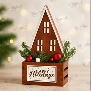 May include: A wooden Christmas decoration shaped like a house, with a brown exterior and white trim. It features windows, festive ornaments, and the text "Happy Holidays". The material width is 3 mm.