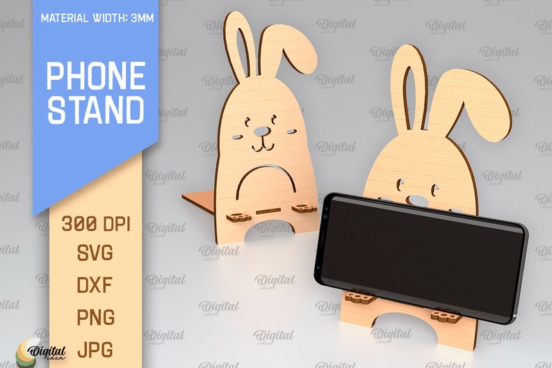 May include: A wooden phone stand shaped like a bunny rabbit. The stand is 3mm thick and is available in SVG, DXF, PNG, and JPG formats. The stand is designed to hold a smartphone upright.