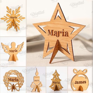 Puede incluir: Una colección de 10 diseños de madera con temática navideña, que incluyen un reno, un copo de nieve, una estrella, un oso, un ángel, un trineo, una corona, una vela, un árbol y un adorno. Cada diseño está cortado con láser de madera de 3 mm de grosor y presenta un nombre.