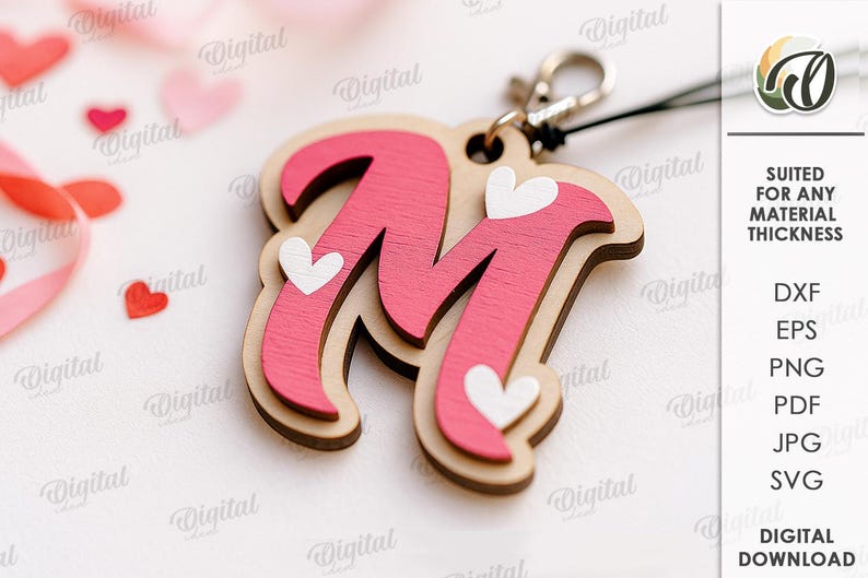 May include: A wooden keychain featuring the letter "M" in pink, adorned with white heart accents. The keychain has a natural wood border and a silver-colored clasp. The background includes scattered heart-shaped confetti and a ribbon.