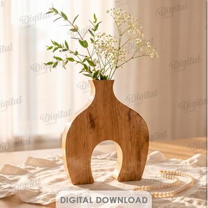 K&ouml;nnte beinhalten: Eine Holzvase mit einem einzigartigen Bogendesign, gef&uuml;llt mit Gr&uuml;n und wei&szlig;en Bl&uuml;ten. Die Vase steht auf einem Tisch mit einem cremefarbenen L&auml;ufer und einer Perlenkette. Der Text "SUITED FOR ANY MATERIAL THICKNESS" ist ebenfalls enthalten.