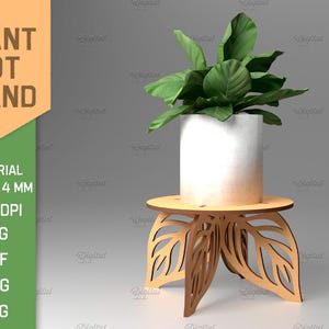 Puede incluir: Un soporte de maceta de planta de madera con un diseño de hojas. El soporte tiene un grosor de 4 mm y está hecho para una imagen de 300 DPI. El soporte se muestra con una maceta blanca y una planta verde.