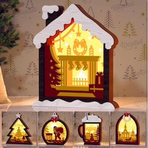 May include: A layered wooden Christmas decoration in the shape of a house with a fireplace scene illuminated from within. The design includes a Christmas tree, stockings, and a wreath. The image also shows four other Christmas-themed designs. The text says "5 DESIGNS" and "DIGITAL DOWNLOAD".