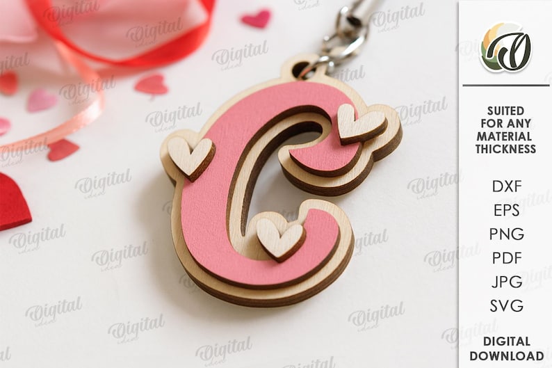 May include: A wooden letter "C" keychain with a pink center and light wood border, adorned with small heart accents. The keychain is on a silver chain, with the text "SUITED FOR ANY MATERIAL THICKNESS" and file type options on the right.