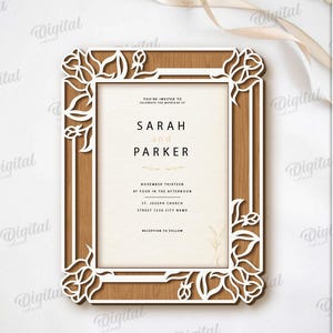 May include: A laser-cut wooden frame with a floral design, holding a wedding invitation. The invitation reads "SARAH and PARKER" with the date and time. The frame is brown with white floral cutouts. Digital download.