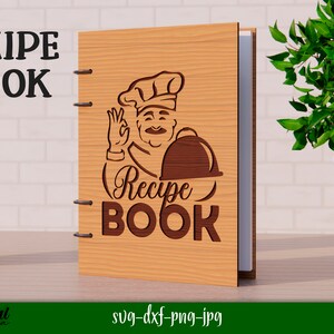 Może przedstawiać: Drewniana okładka książki kucharskiej z kresk&oacute;wkowym kucharzem trzymającym tacę. Tekst "Recipe Book" jest napisany ozdobnym fontem.