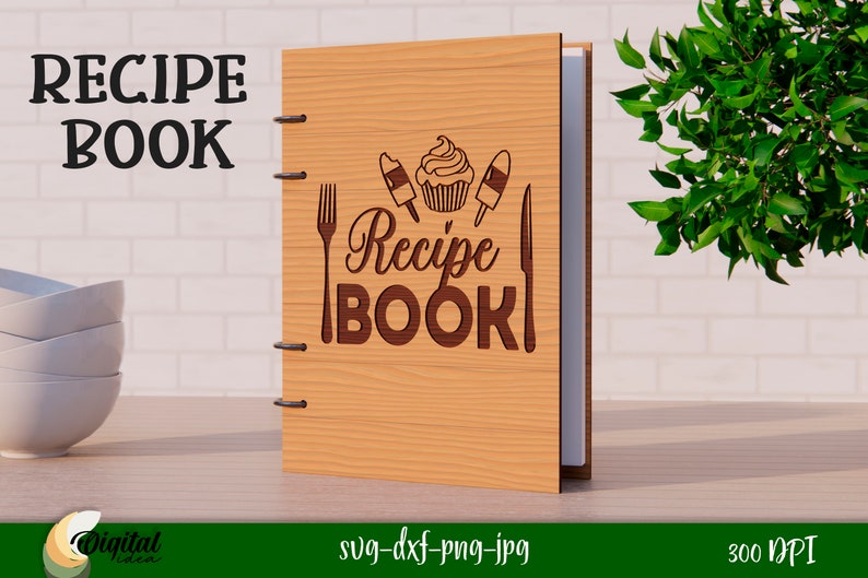 Może przedstawiać: Drewniana książka kucharska z brązową okładką i wzorem ciastka, dw&oacute;ch lod&oacute;w na patyku, widelca i noża. Tekst "Recipe Book" jest napisany brązowym kolorem na okładce.