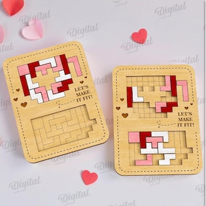 May include: Two wooden puzzle games with red, pink, and white block designs and the text "LET'S MAKE IT FIT!" are displayed. The puzzles are surrounded by paper hearts in shades of red and pink, creating a romantic theme.