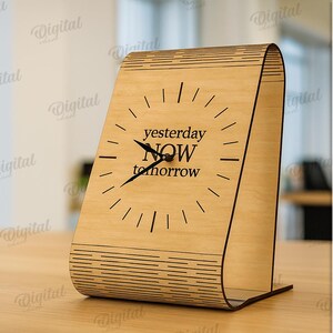 K&ouml;nnte beinhalten: Eine Holz-Schreibtischuhr mit den Worten "yesterday NOW tomorrow" auf dem Zifferblatt. Die Uhr ist aus hellfarbenem Holz gefertigt und hat ein einzigartiges, geschwungenes Design. Die Uhr ist 3 mm breit.
