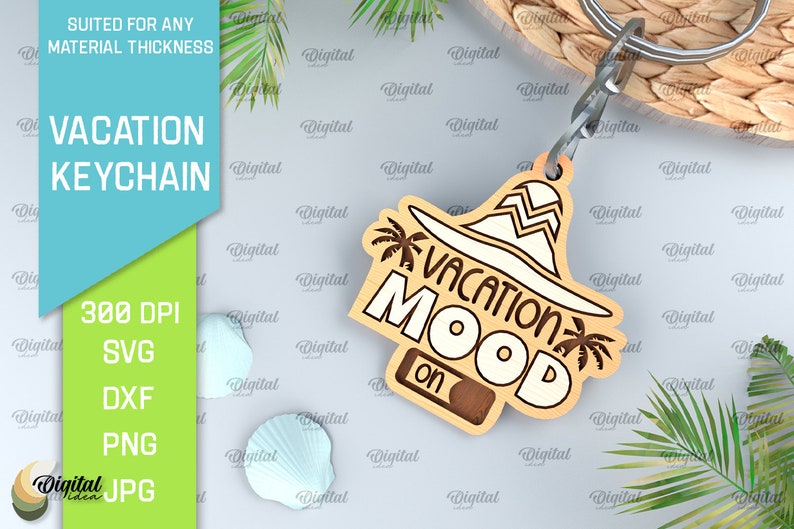May include: A wooden keychain with a brown and white design. The keychain features a sun hat with palm trees and the text "Vacation Mood On".